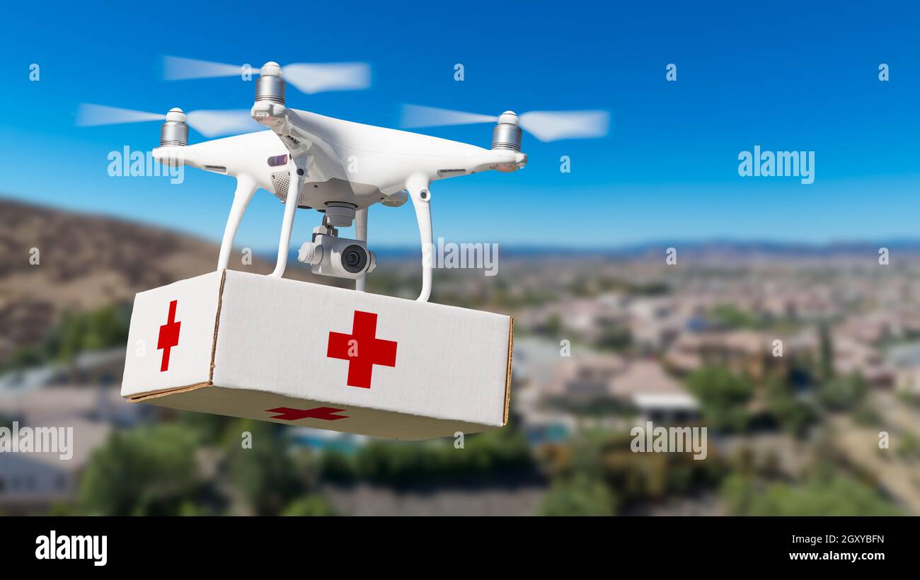 Unmanned Aircraft Systems (UAS) Quadcopter Drone mit Erste Hilfe Paket über die Nachbarschaft. Stockfoto