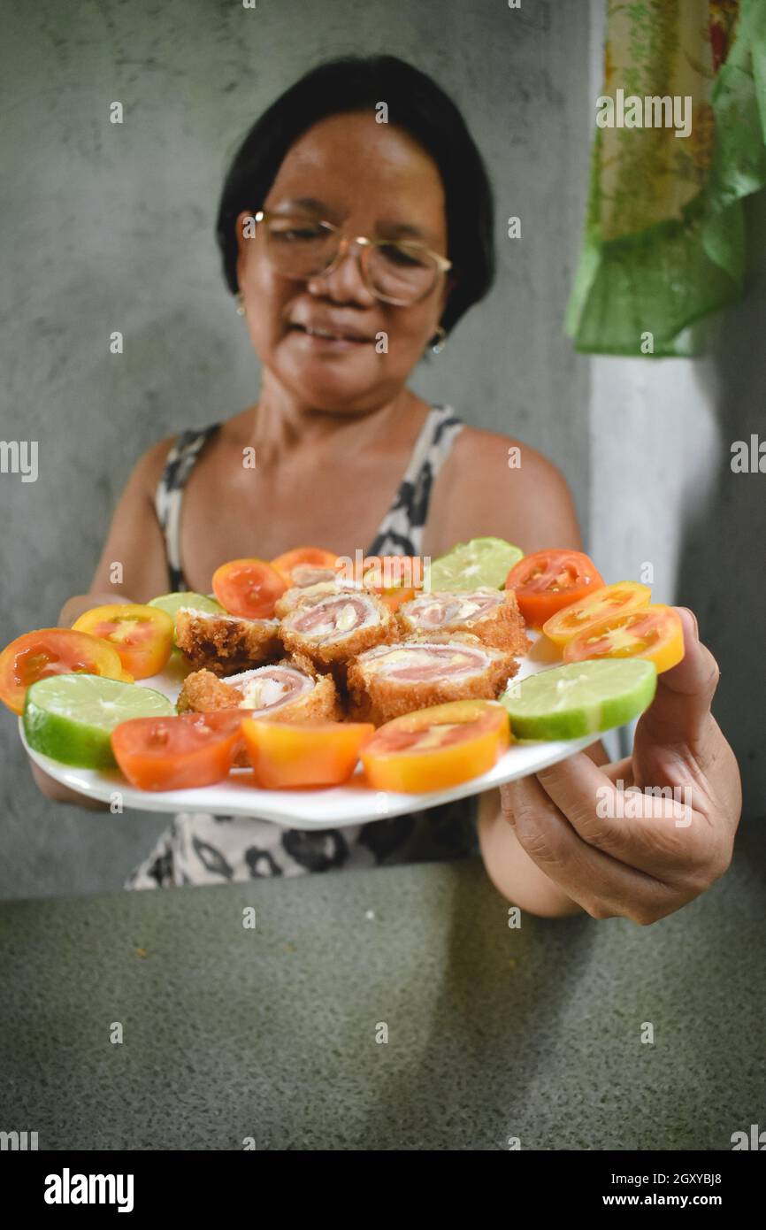 Asiatische Frau teilt Cordon bleu Stockfoto