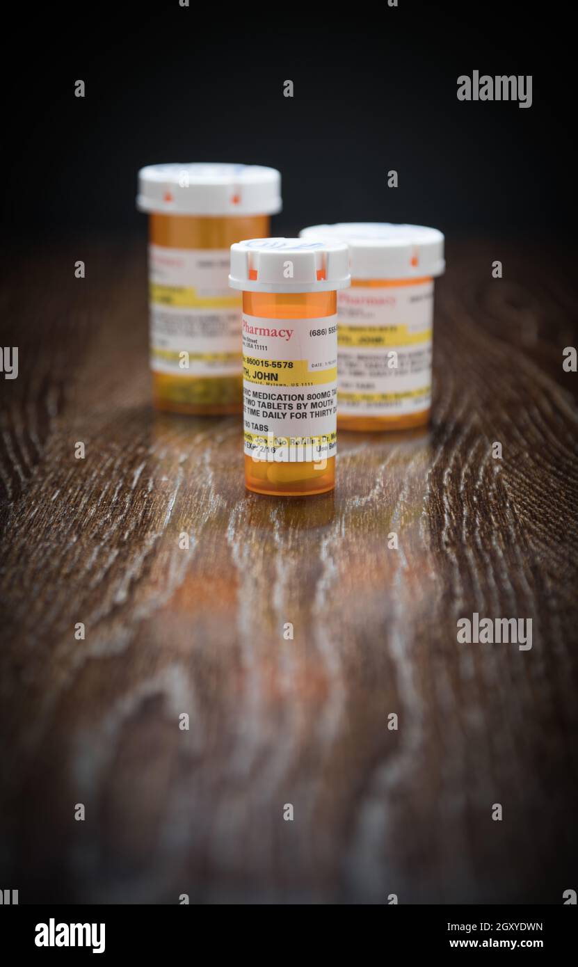 Vielzahl von Non-Proprietary Medizin Flaschen auf reflektierenden Holz- Oberfläche. Stockfoto