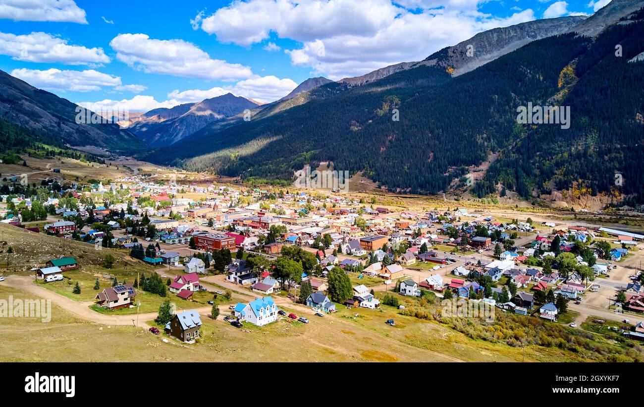 Große Bergkette, die kleine westliche Stadt im Tal umgibt Stockfoto