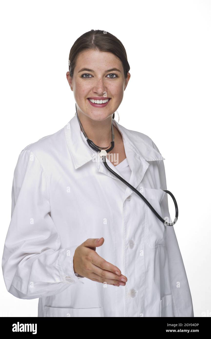 Lächelnde junge Ärztin mit Stethoskop, das die Hand ausstreckte Stockfoto