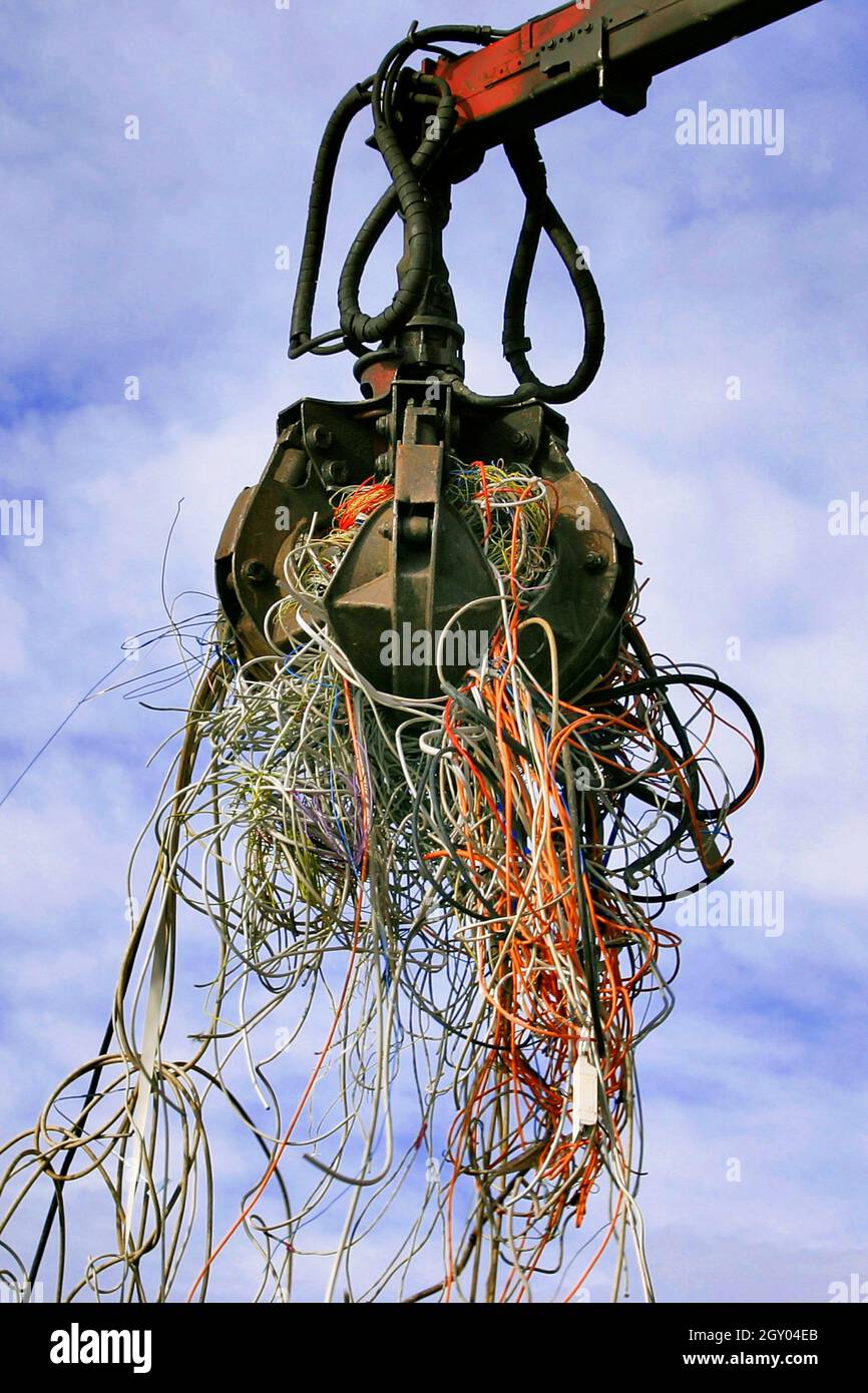 Schaufel mit E-Abfall, alte Kabel auf einer Mülldeponie Sanitär, Österreich Stockfoto