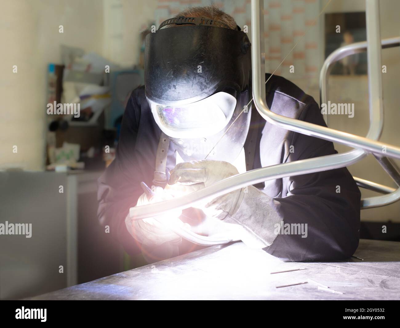 Schweißer beim Aufrichten von Stahl in einer Fertigungsfabrik. Metallbauer, der an seinem Ingenieurarbeitsplatz arbeitet. Stockfoto