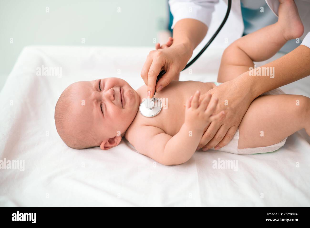 Nettes kaukasisches Neugeborenes, das sich einer medizinischen Untersuchung unterziehen wird Stockfoto