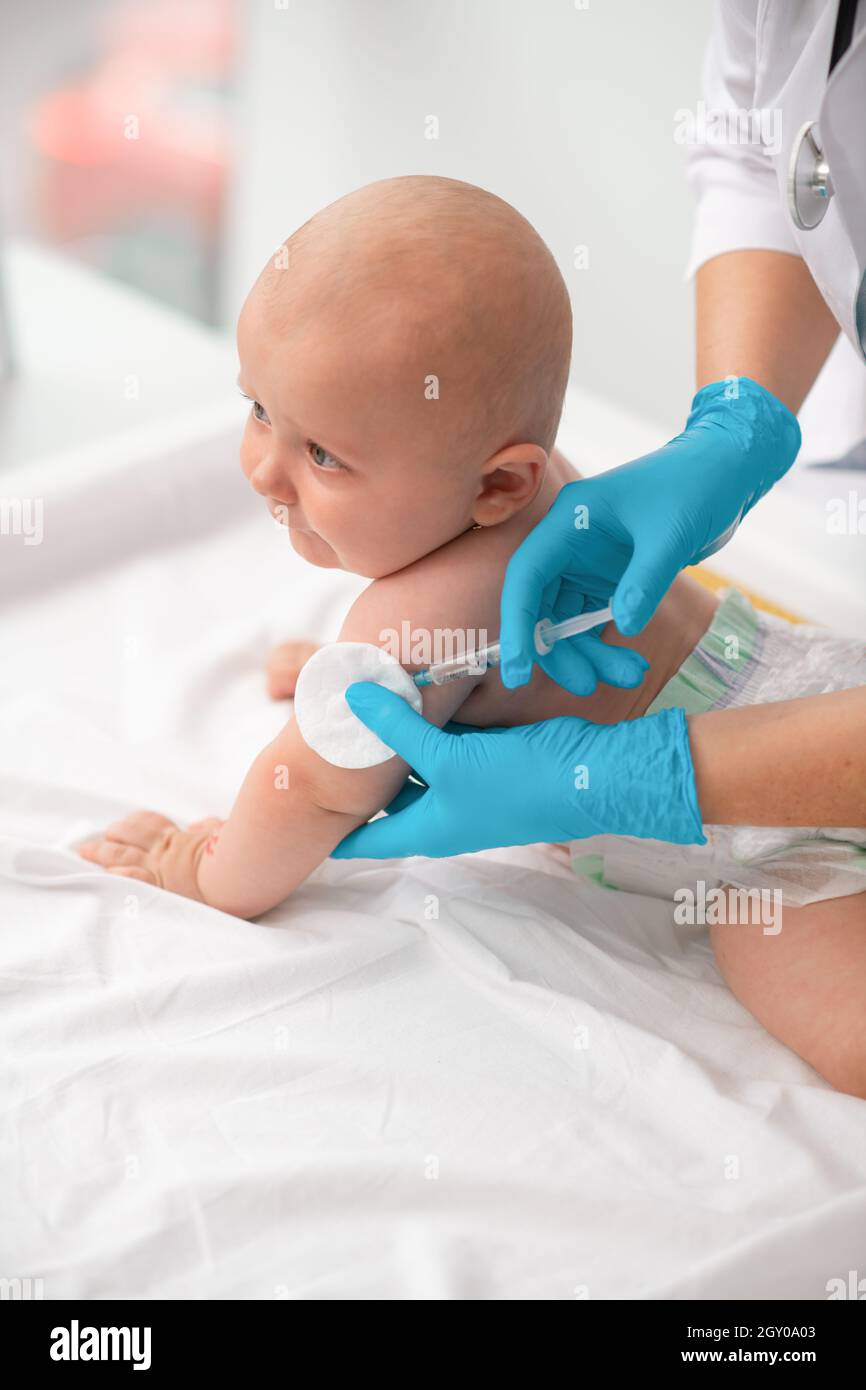 Das Baby erhält eine Injektion im Oberarm Stockfoto
