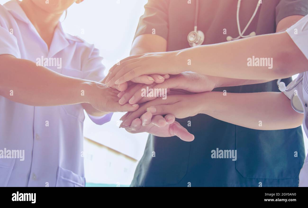 Ärzte und Krankenschwestern in einem medizinischen Team, das sich die Hände stapelt. Chirurg Ärzte Menschen Händeschütteln. Medizinisches Personal in Uniform arbeitet in der Klinik zusammen. gree Stockfoto