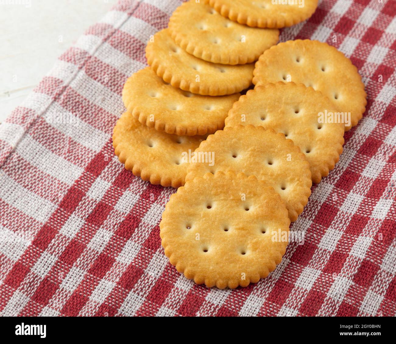 Cracker Kekse mit Tischdecke auf weißem Holztisch Hintergrund. Stockfoto