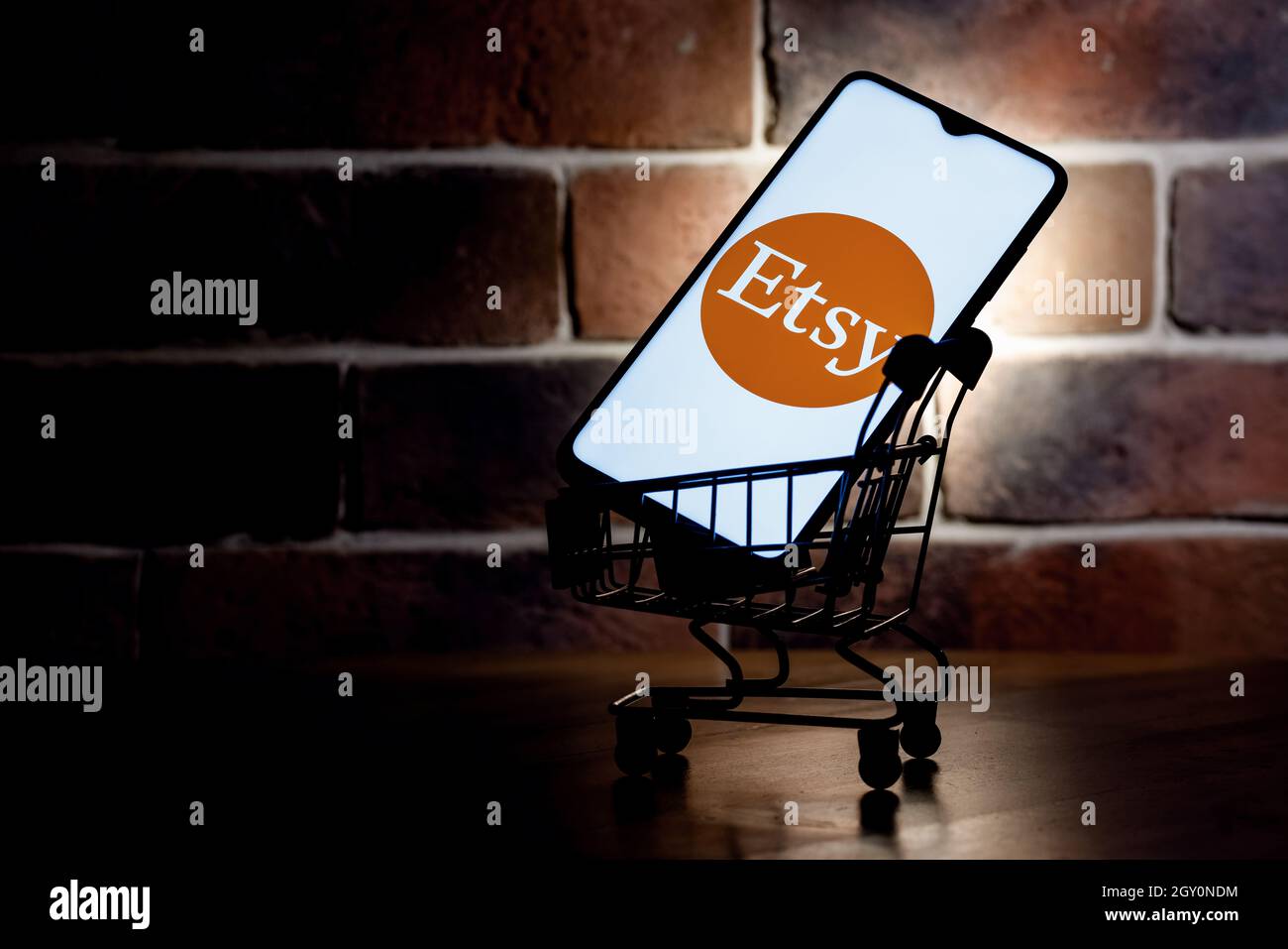 Smartphone mit Etsy-Logo auf dem Bildschirm im Warenkorb. Stockfoto