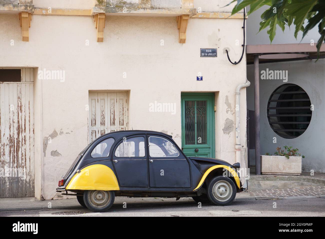 Vintage-Fahrzeug, schwarz und gelb in der Farbe geparkt auf der Straße vor dem Haus im Dorf in Frankreich Stockfoto
