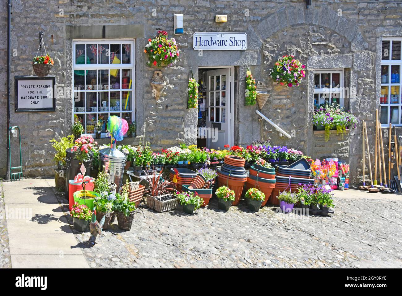 Sommertime Topf gewachsen Sommer Blumen & Gartenartikel außerhalb Steinwand Eisenwaren Einzelhandel Geschäft Grassington Wharfedale Yorkshire England Stockfoto