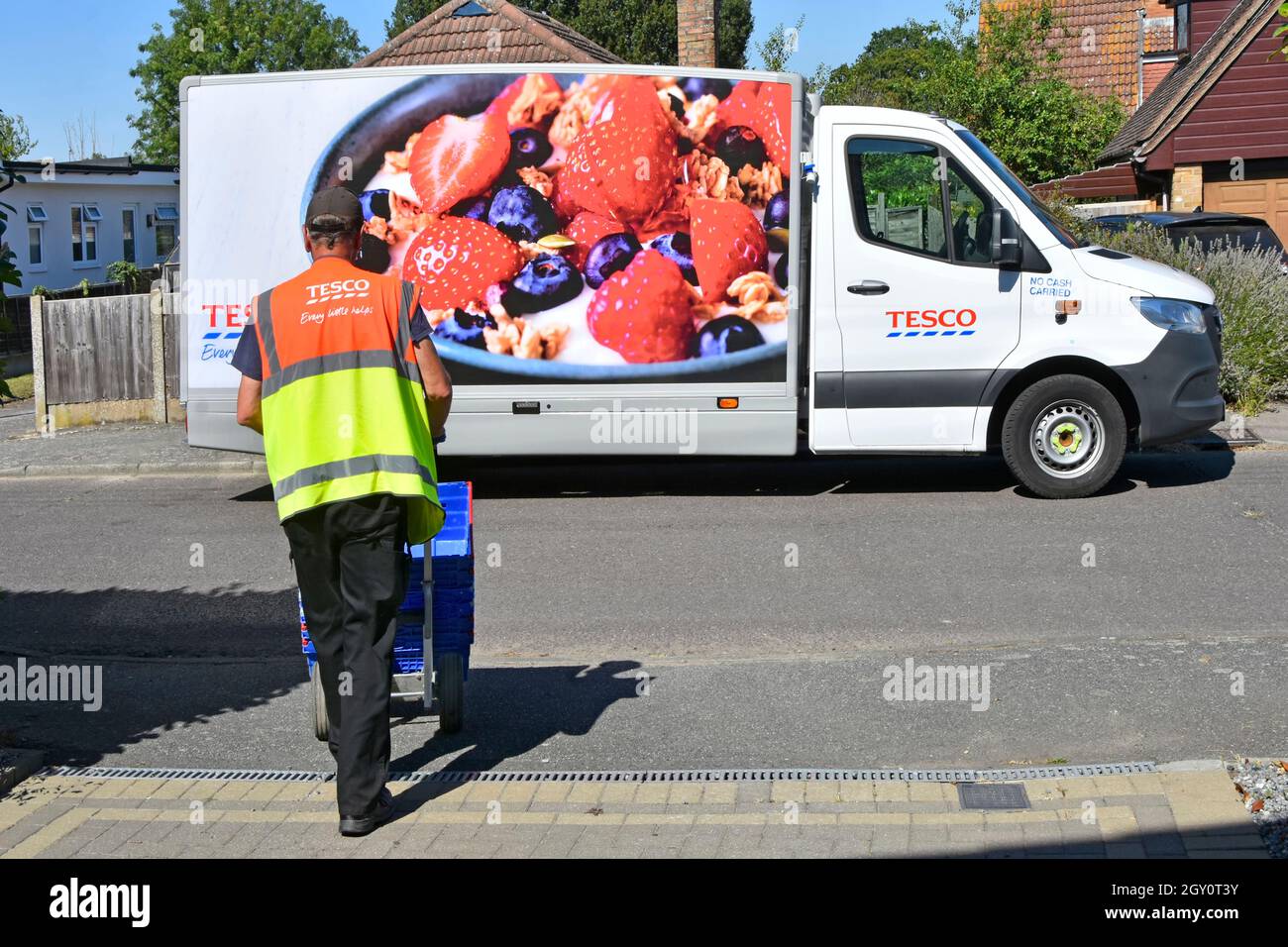 Blick auf Tesco Supermarkt Lebensmittelfahrer hohe Sichtbarkeit Mitarbeiter Uniform gibt leere Kisten zurück zu Van von zu Hause Lieferung an Online-Kunden Essex UK Stockfoto
