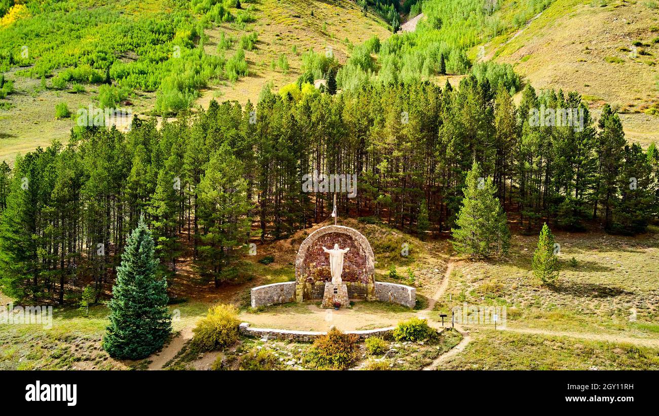 Jesus Christus der Mine Statue des Respekts in den Bergen, umgeben von Kiefern Stockfoto