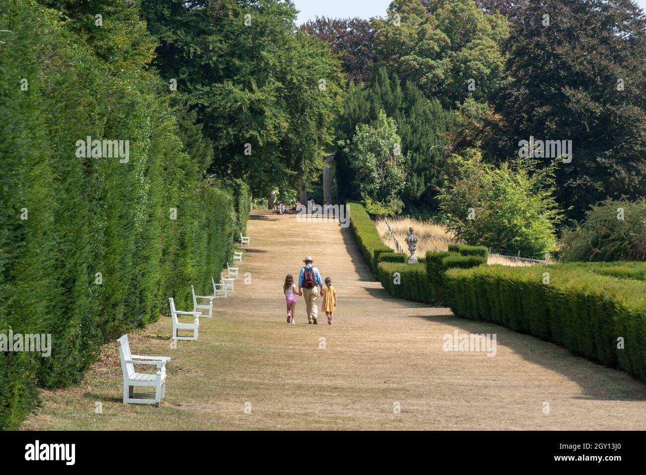 Besucher, die während des Sommers den langen Spaziergang auf dem Landgut Polesden Lacey in Surrey, Großbritannien, Unternehmen Stockfoto