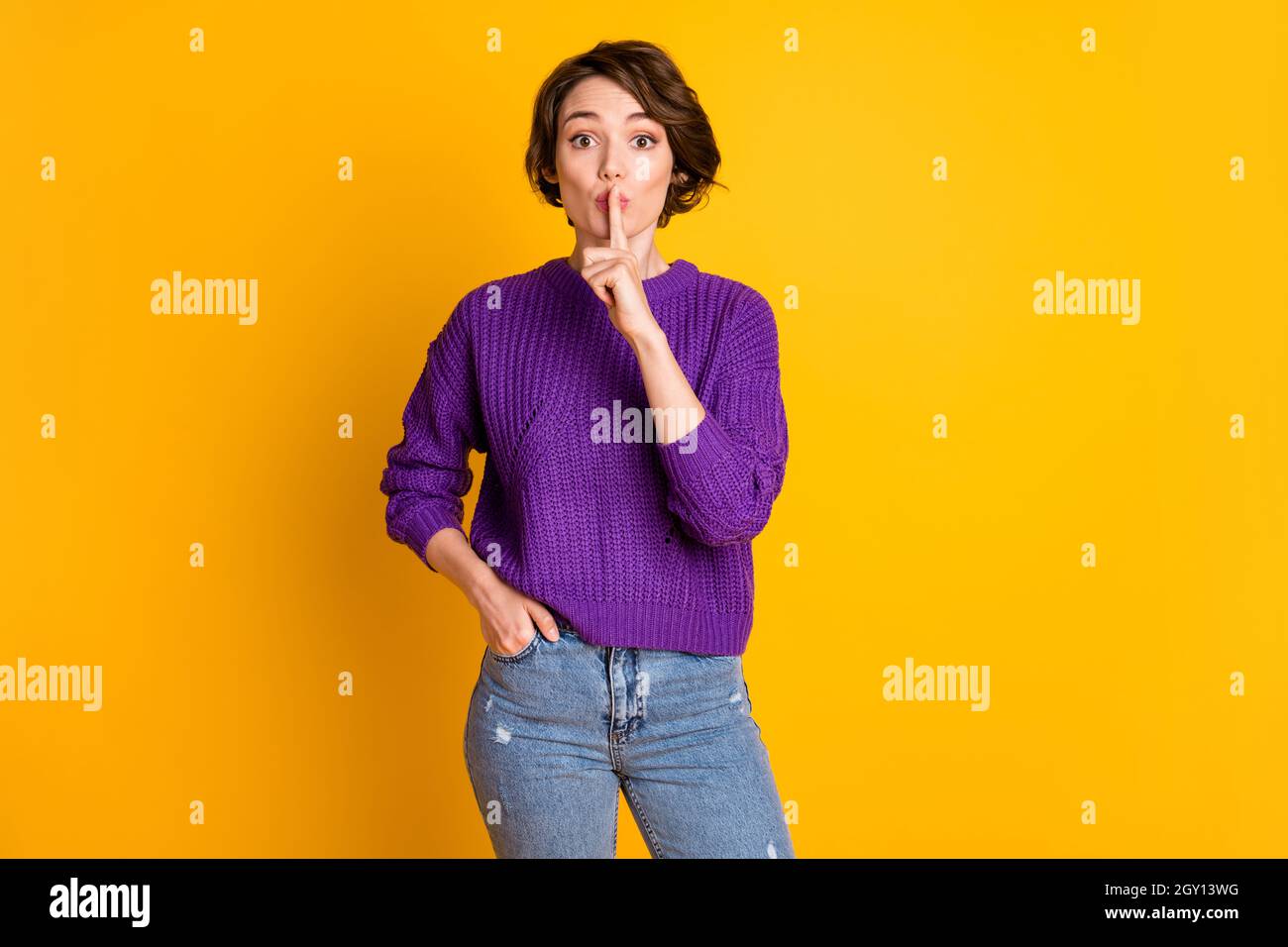 Portrait von attraktiven geheimnisvollen Mädchen zeigt shh Zeichen stumme Info isoliert über helle gelbe Farbe Hintergrund Stockfoto