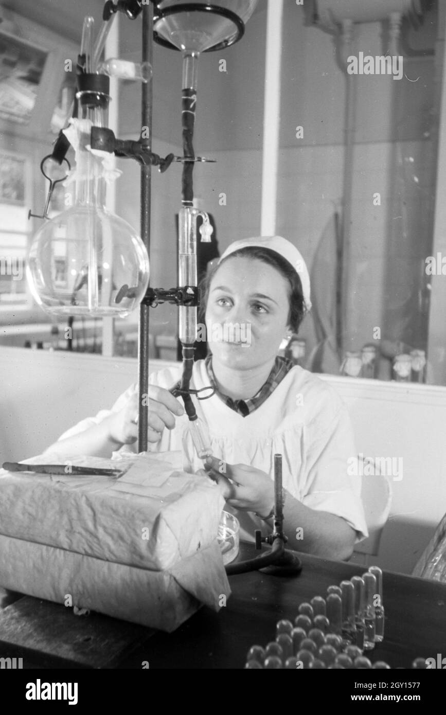 Eine Laborantin fertigt in Arbeit der Behringwerke Proben eines Medikaments ein, Marburg, Deutschland 1930er Jahre. Eine Lab Assistant ist die Einnahme von Medikamenten Proben im Labor der Behringwerke, Marburg, Deutschland 1930. Stockfoto