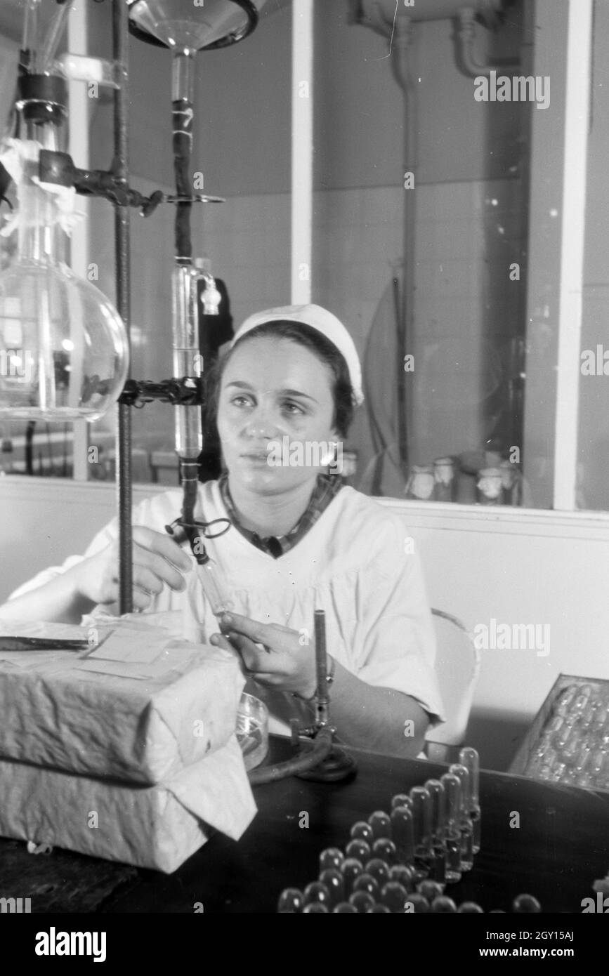 Eine Laborantin fertigt in Arbeit der Behringwerke Proben eines Medikaments ein, Marburg, Deutschland 1930er Jahre. Eine Lab Assistant ist die Einnahme von Medikamenten Proben im Labor der Behringwerke, Marburg, Deutschland 1930. Stockfoto