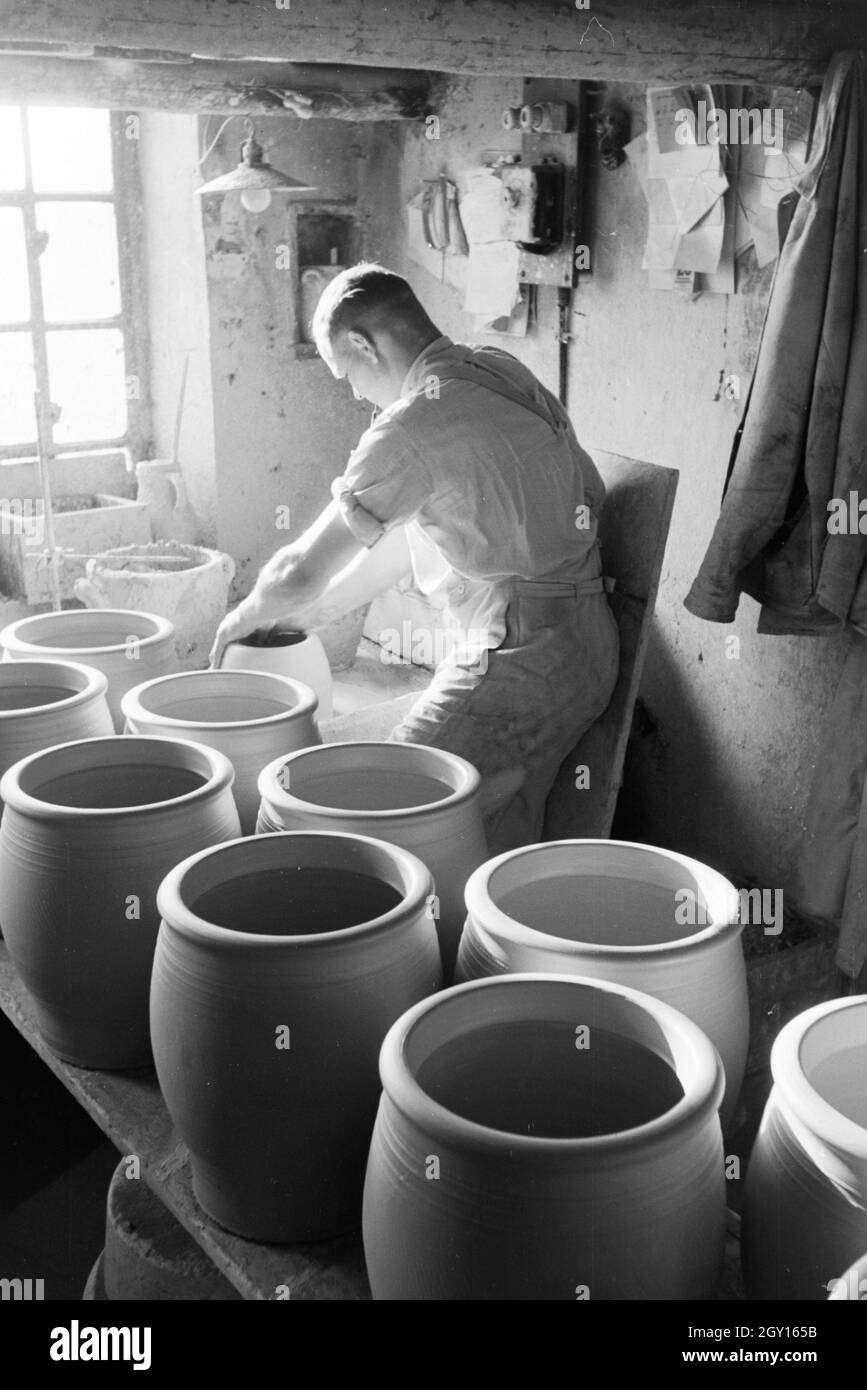 Ein Töpfermeister bei der Produktion von tonkrügen an der Töpferscheibe im Kannenbäckerland, Deutschland 1930er Jahre. Ein Master Potter arbeiten an steinzeug Krüge mit der Töpferei Rad im Kannenbäckerland, Deutschland 1930. Stockfoto