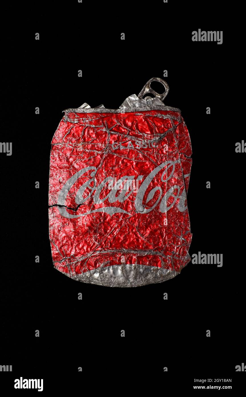 Abgeflachte Coca-Cola-Dose auf dunkelschwarzem Hintergrund Stockfoto