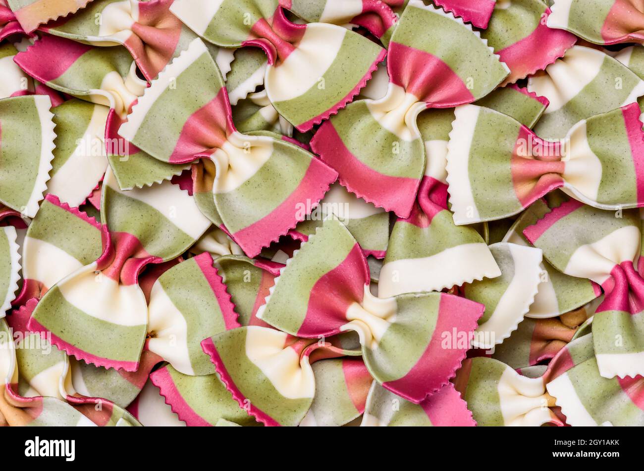 Italienische Pasta Hintergrund. Pasta Farfalle Draufsicht, flach liegend. Farbenfrohe traditionelle italienische Küche. Stockfoto