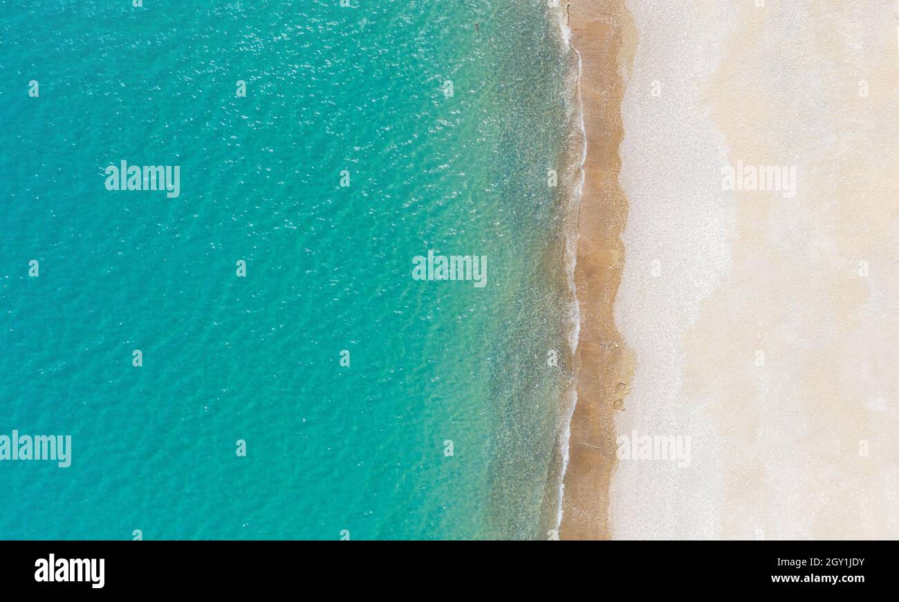 Leerer weißer Sandstrand und ruhiges türkisfarbenes Meer. Luftaufnahme direkt oben, Hintergrund mit Kopierraum Stockfoto
