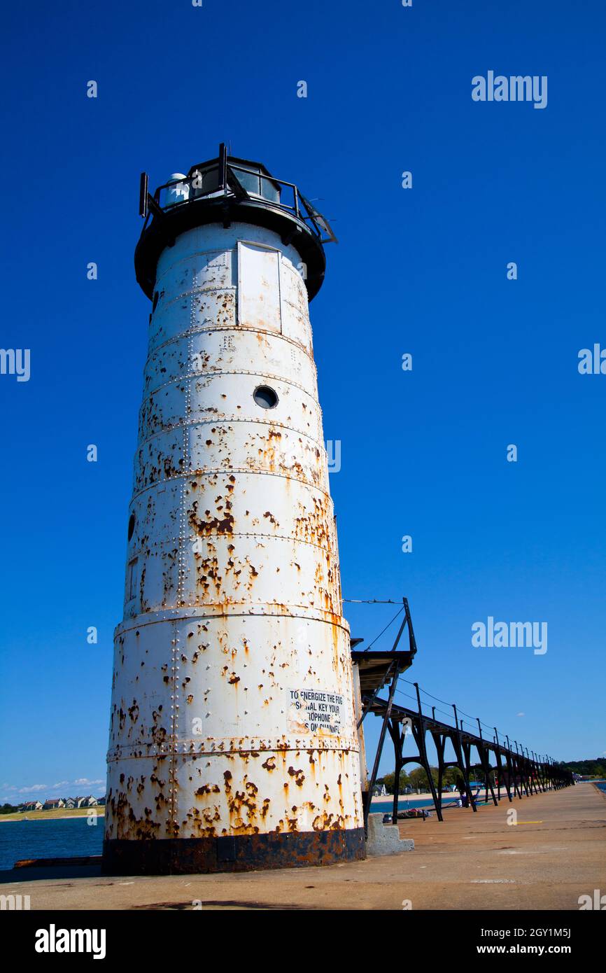 Weiß verrosteten Leuchtturm am Ende eines langen hölzernen Pier vor einem klaren blauen Himmel Stockfoto