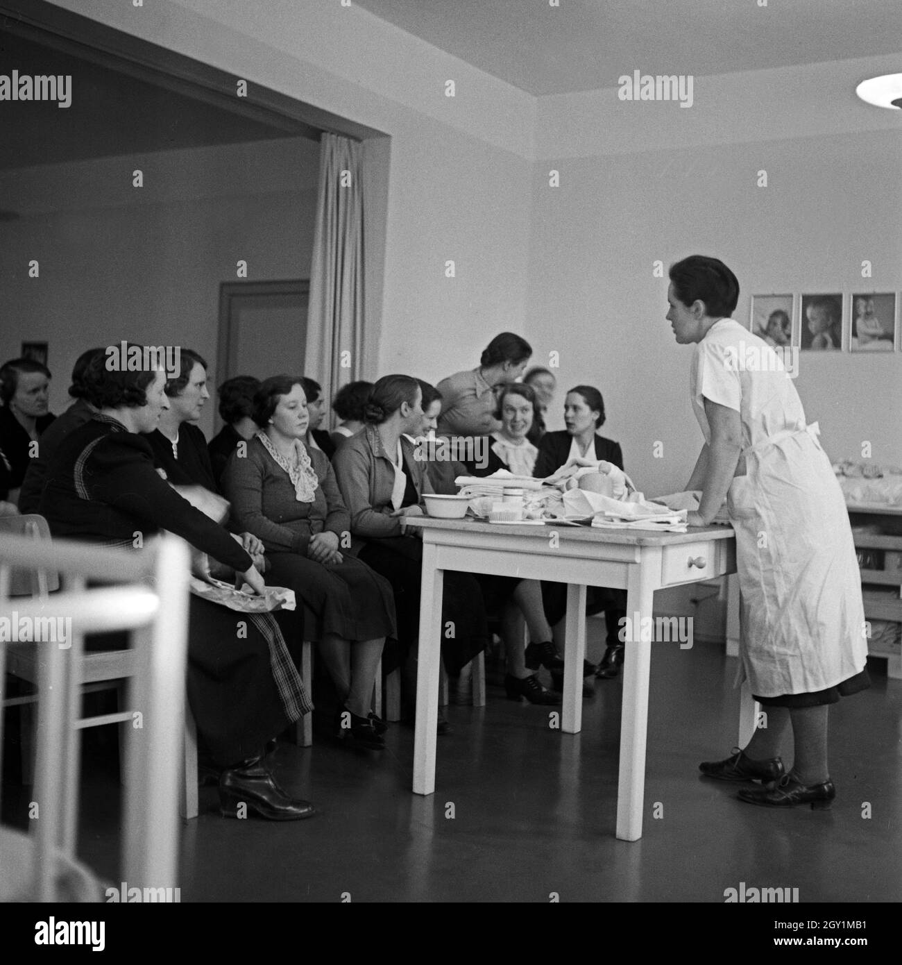 Frauen lernen Windelwechsel bei einer Mütterschulung des Reichsmütterdienstes in Essen teil, Deutschland 1930er Jahre. Frauen erfahren Sie, wie Sie die Windeln des Babys auf eine Mutter Ausbildung der Reichsmuetterdienst in Essen, Deutschland 1930 s zu ändern. Stockfoto