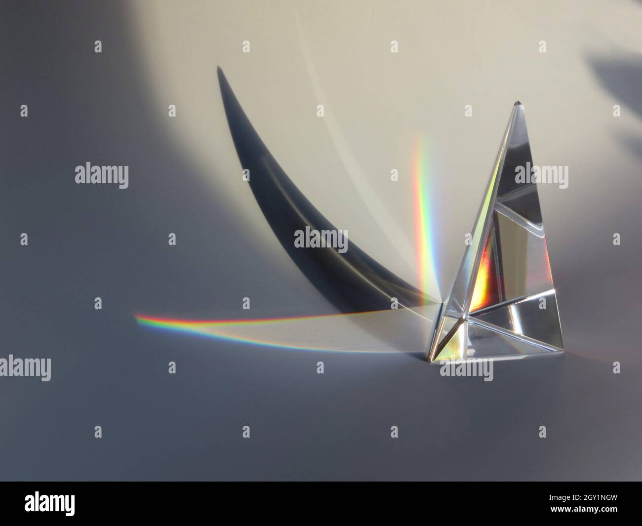 Glasprisma im Sonnenlicht mit Regenbogen und Schatten Stockfoto