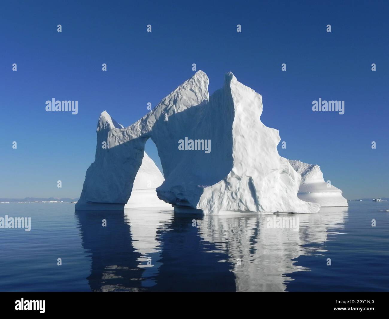 Großer Eisberg im arktischen Ozean in blauem Himmel Stockfoto