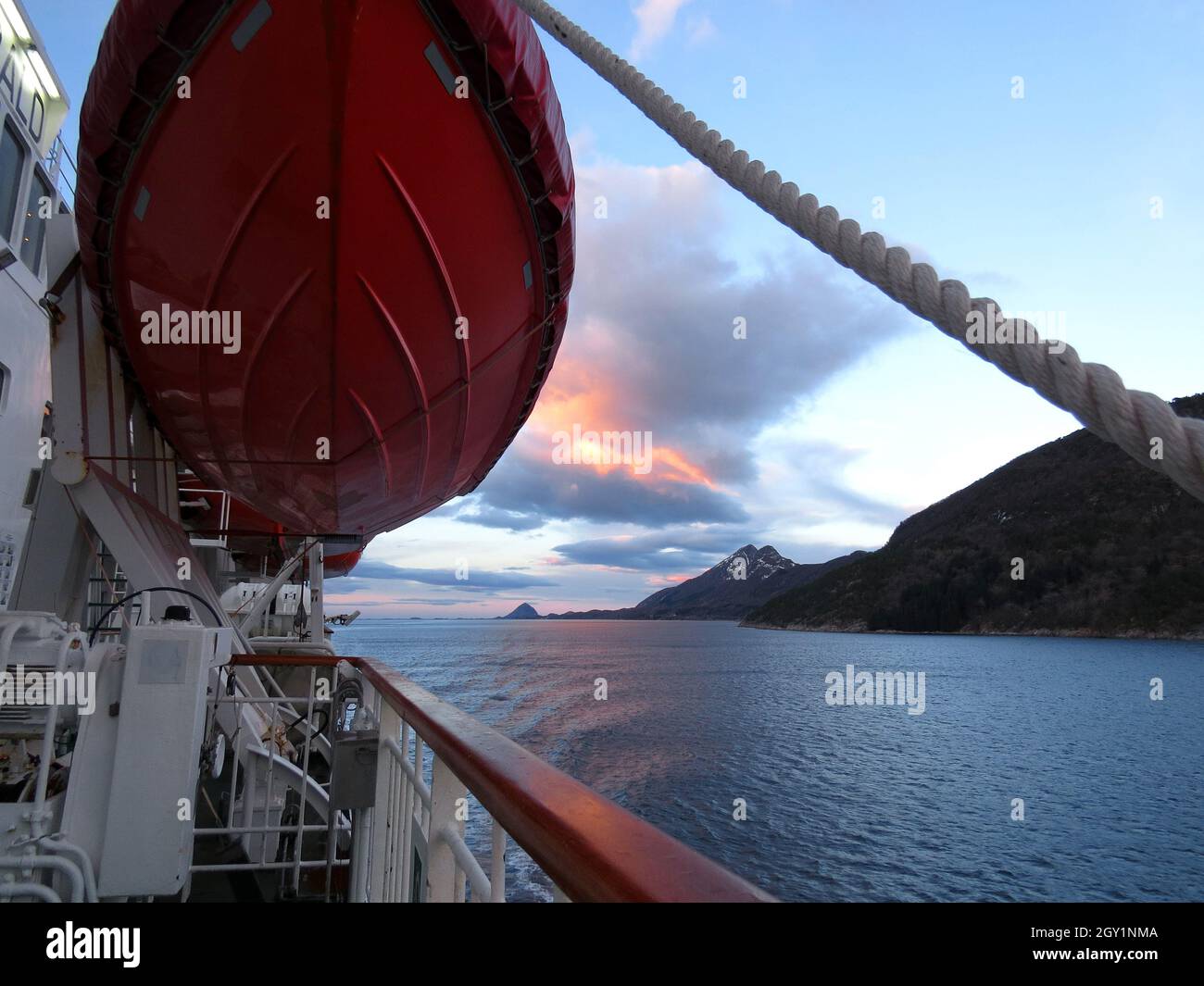 Rotes Rettungsschiff mit Blick auf den arktischen Ozean mit felsigen Bergen Stockfoto