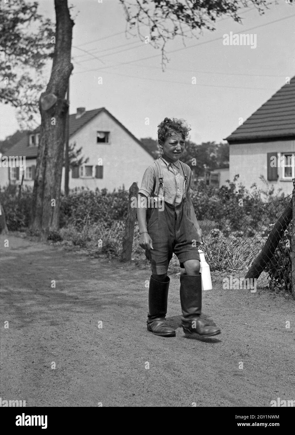 Ein Kleiner Junge Geht Milch Holen, 1930er Jahre Deutschland. Ein wenig junge nehmen Milch, Deutschland der 1930er Jahre. Stockfoto