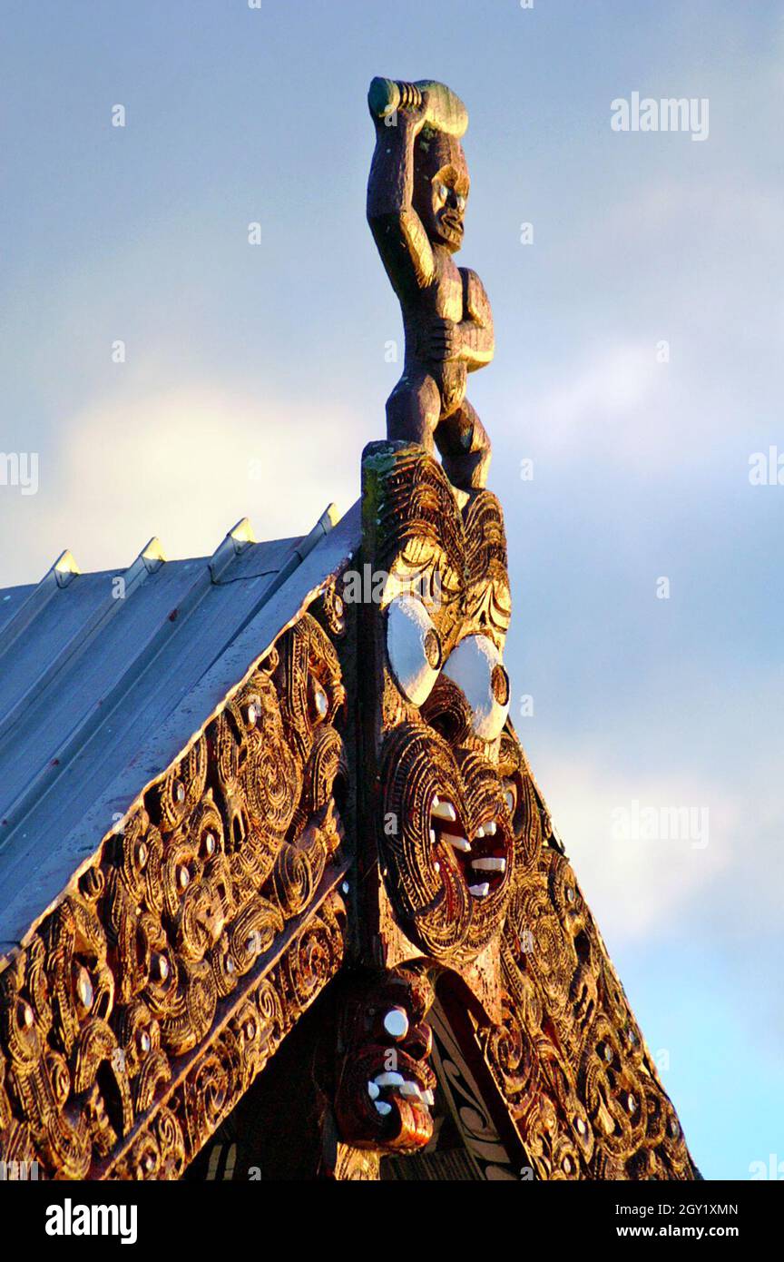 Der Giebel eines Maori Meeting House in Rotorua, Neuseeland, mit seinem hölzernen Tekoteko, das Vorfahren, Schutz und Vormundschaft über das Whare Whakairo repräsentiert. Stockfoto