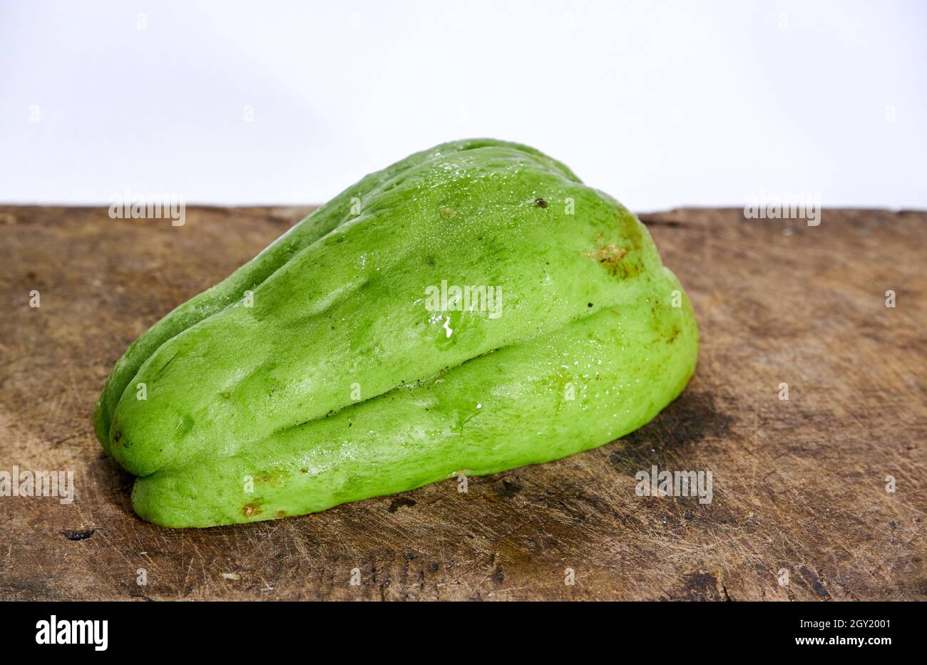 Chayote auf einem hölzernen Schneidebrett isoliert auf weißem Hintergrund Stockfoto