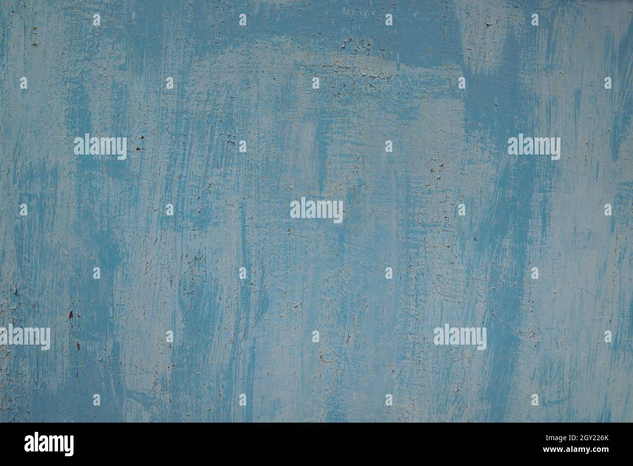 Textur von weißer und blauer Peeling-Farbe. Textur von zwei Schichten alter rissiger Farbe auf einer Ebenen Metalloberfläche mit Spuren von Rost, hohe Auflösung. Stockfoto