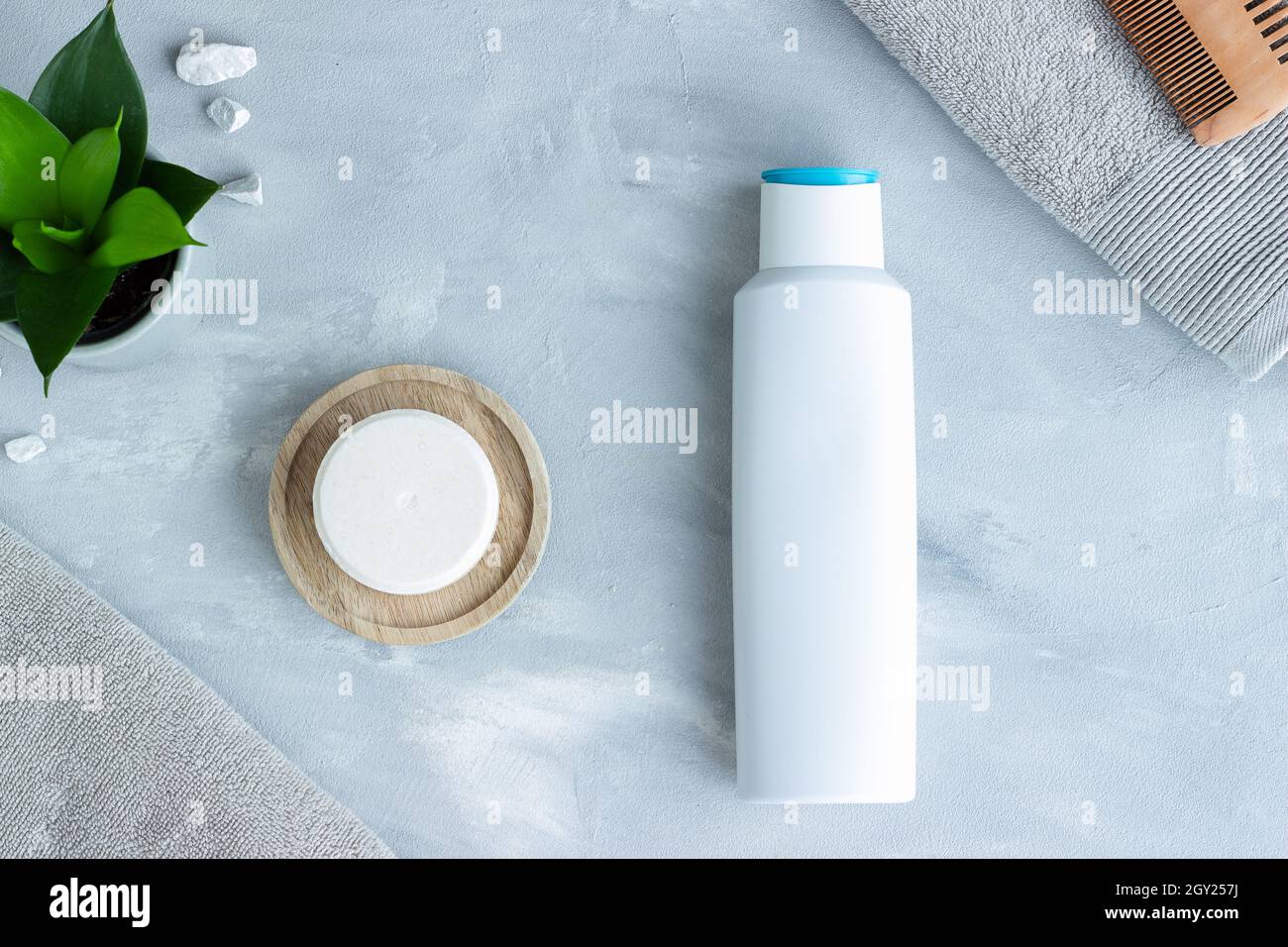 Eine Bar mit Shampoo und eine Plastikflasche mit Shampoo nebeneinander; nachhaltiger Lebensstil Stockfoto