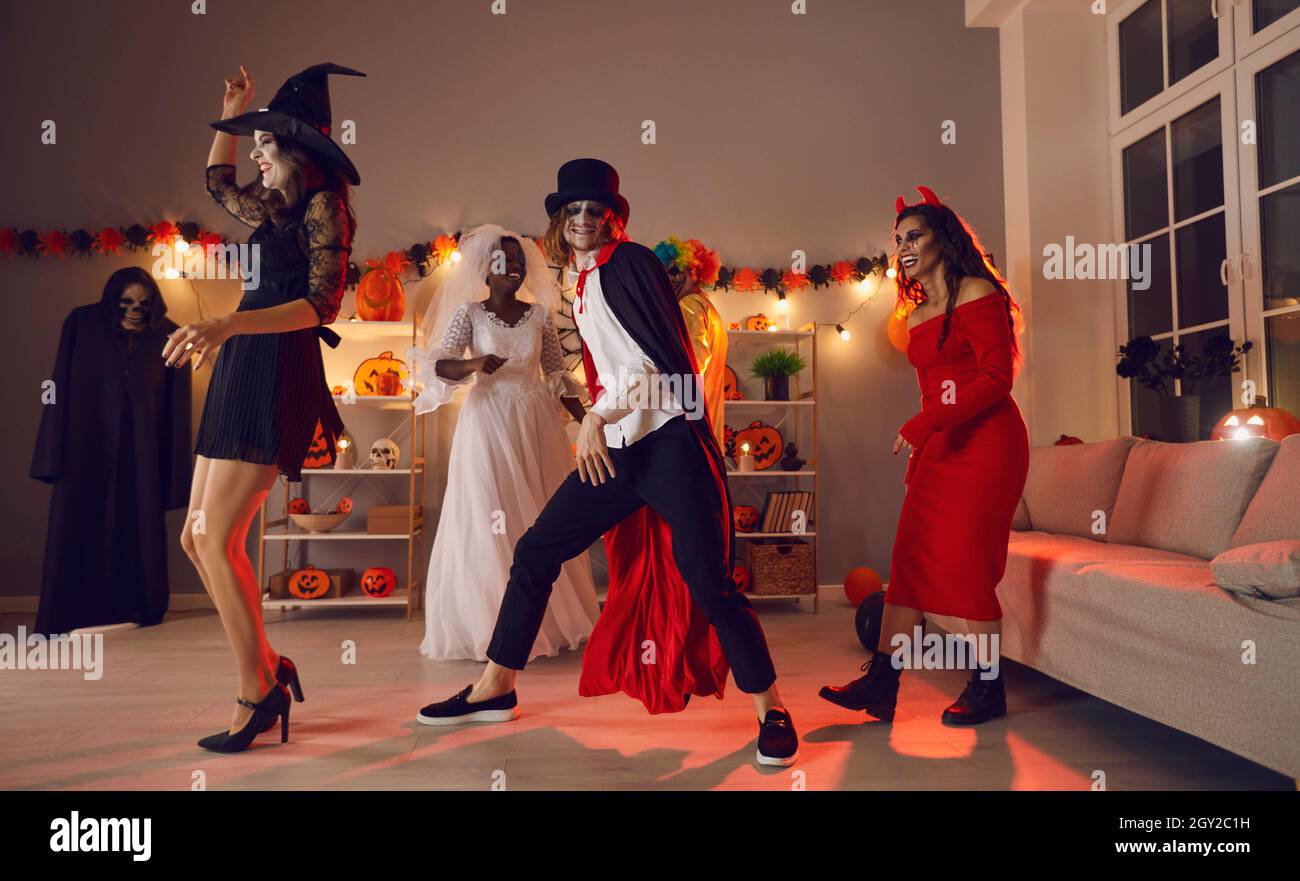 Fröhliche junge Menschen tanzen und haben Spaß auf der festlichen Kostümparty an Halloween Stockfoto