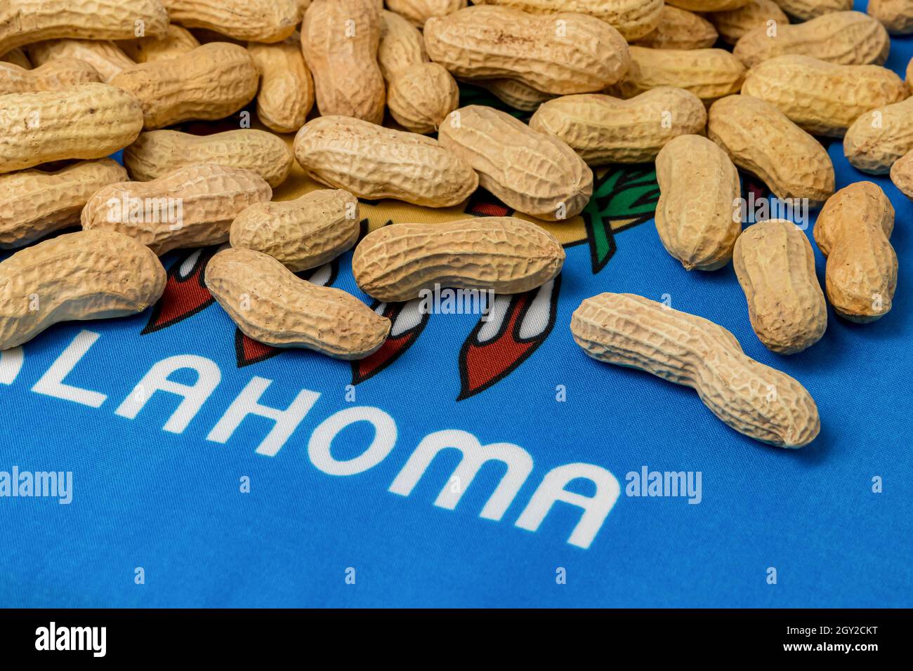Erdnüsse in Schale auf Flagge von Oklahoma. Erdnussanbau, Handel, Zölle und Marktpreiskonzept. Stockfoto