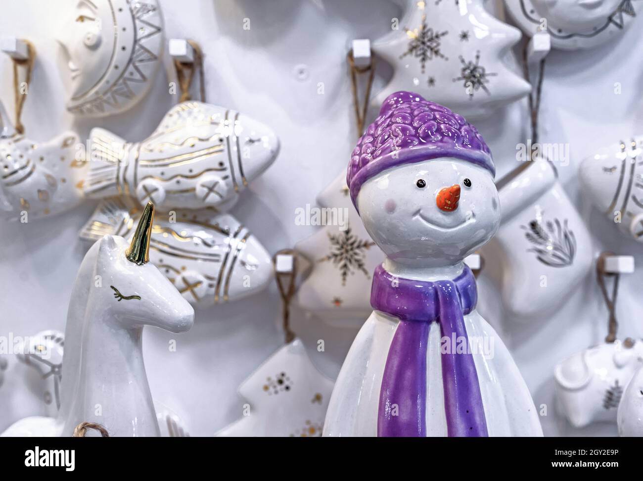 Keramik-Statuette eines Schneemanns in einem lila Hut und Schal. Stockfoto