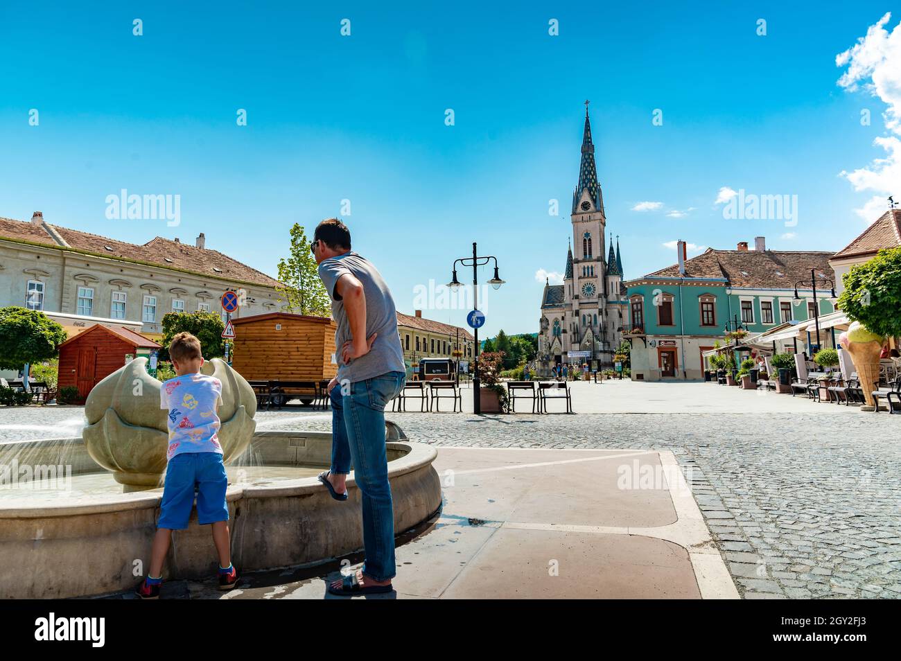 KOSZEG, UNGARN - 14. AUGUST 2021: Blick auf die Herz-Jesu-Kirche oder Koszegi Jezus szive plebaniatemplom und die Menschen auf dem Main Squre oder Fo ter o Stockfoto