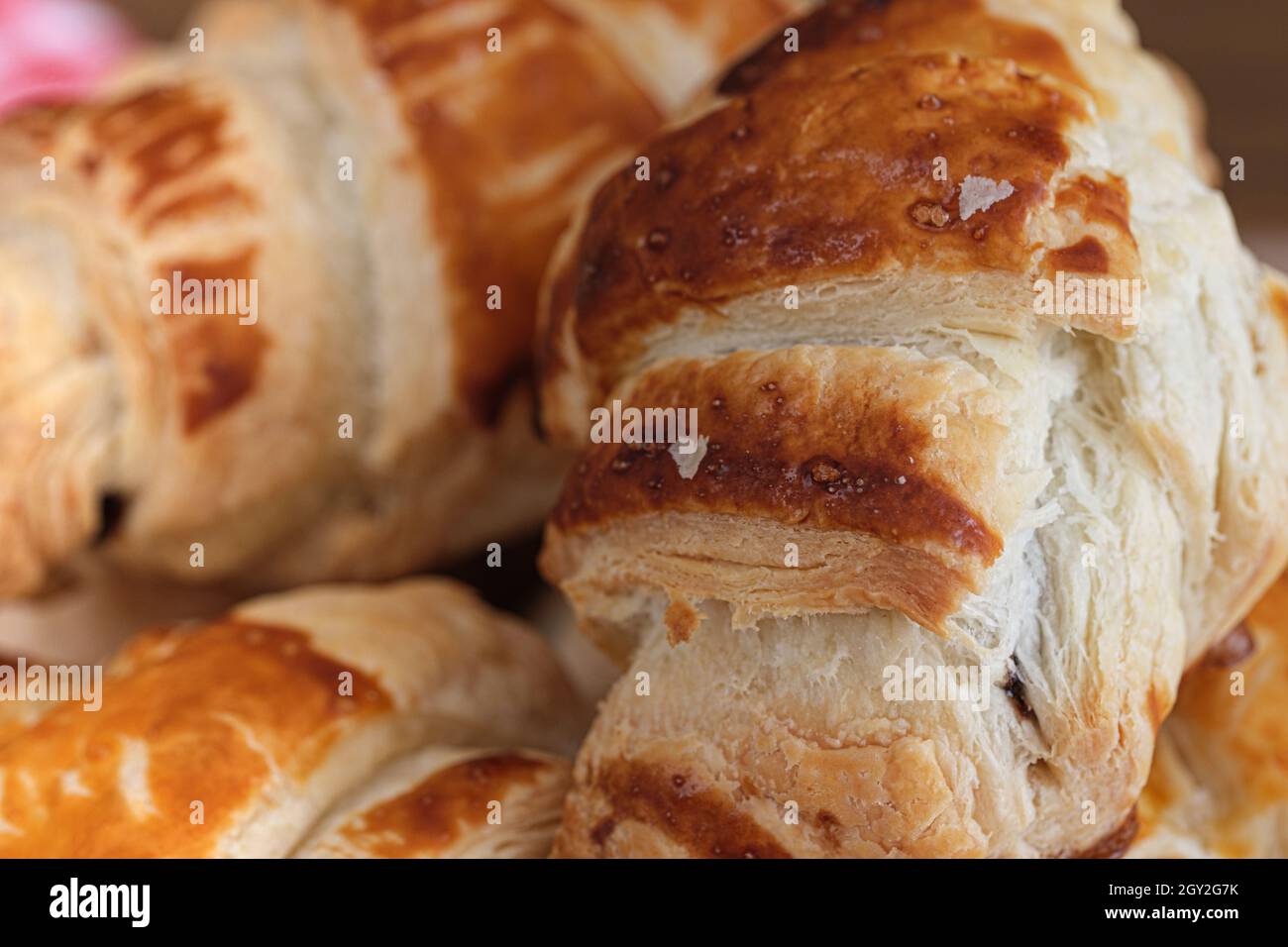 Makroaufnahme von knusprigen Croissants. Frische braune Croissants, beliebte Frühstücks- oder Mittagszutaten in französischer Kultur. Selektiver Fokus. Stockfoto