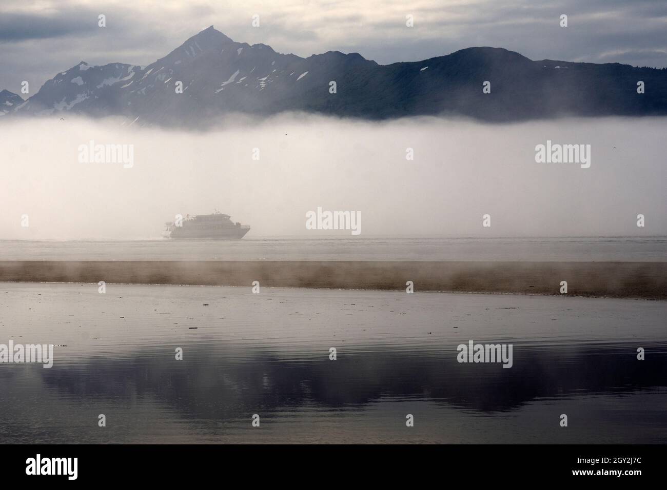 Ein Boot korsiert den Morgennebel in Kachemak Bay, Homer, Alaska, USA Stockfoto