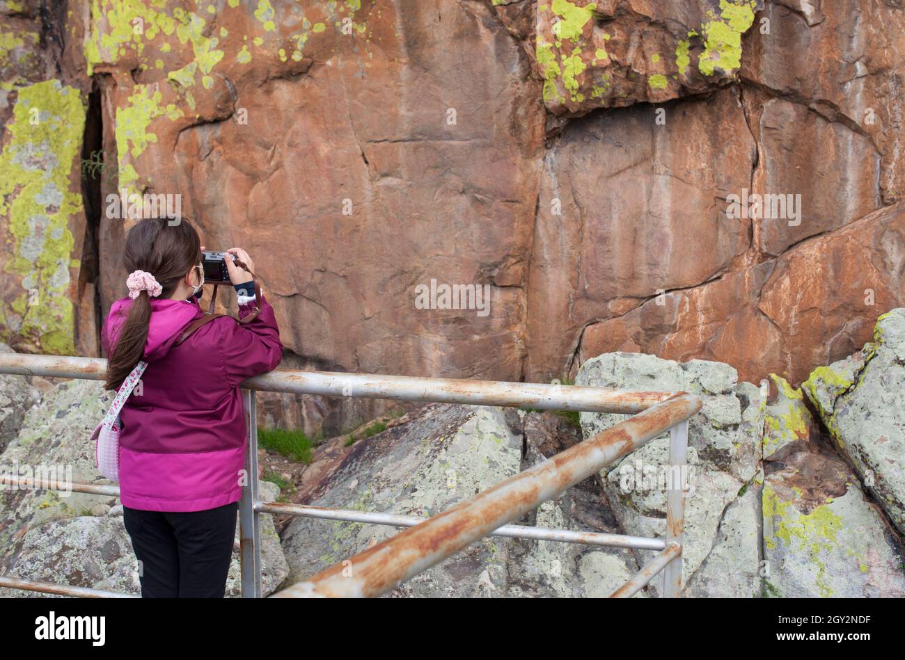 Kleines Mädchen, das Fotos von San Blas Rock Tierheim mit prähistorischen Gemälden. Alburquerque, Badajoz, Extremadura, Spanien Stockfoto