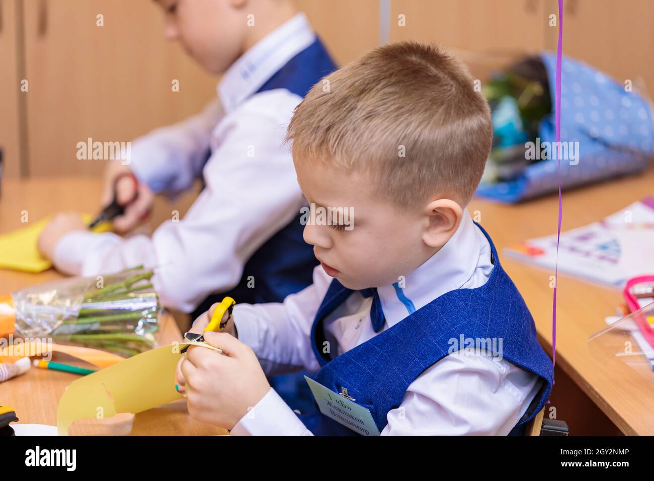 Erstklässler in der Lektion schneiden Zahlen für Anwendungen aus Papier aus. Schule, Wissenstag. Moskau, Russland, 1. September 2021 Stockfoto