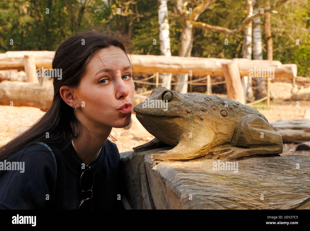 Ein junges Mädchen küsst einen Frosch, um ihn in einen hübschen Prinzen zu verwandeln Stockfoto