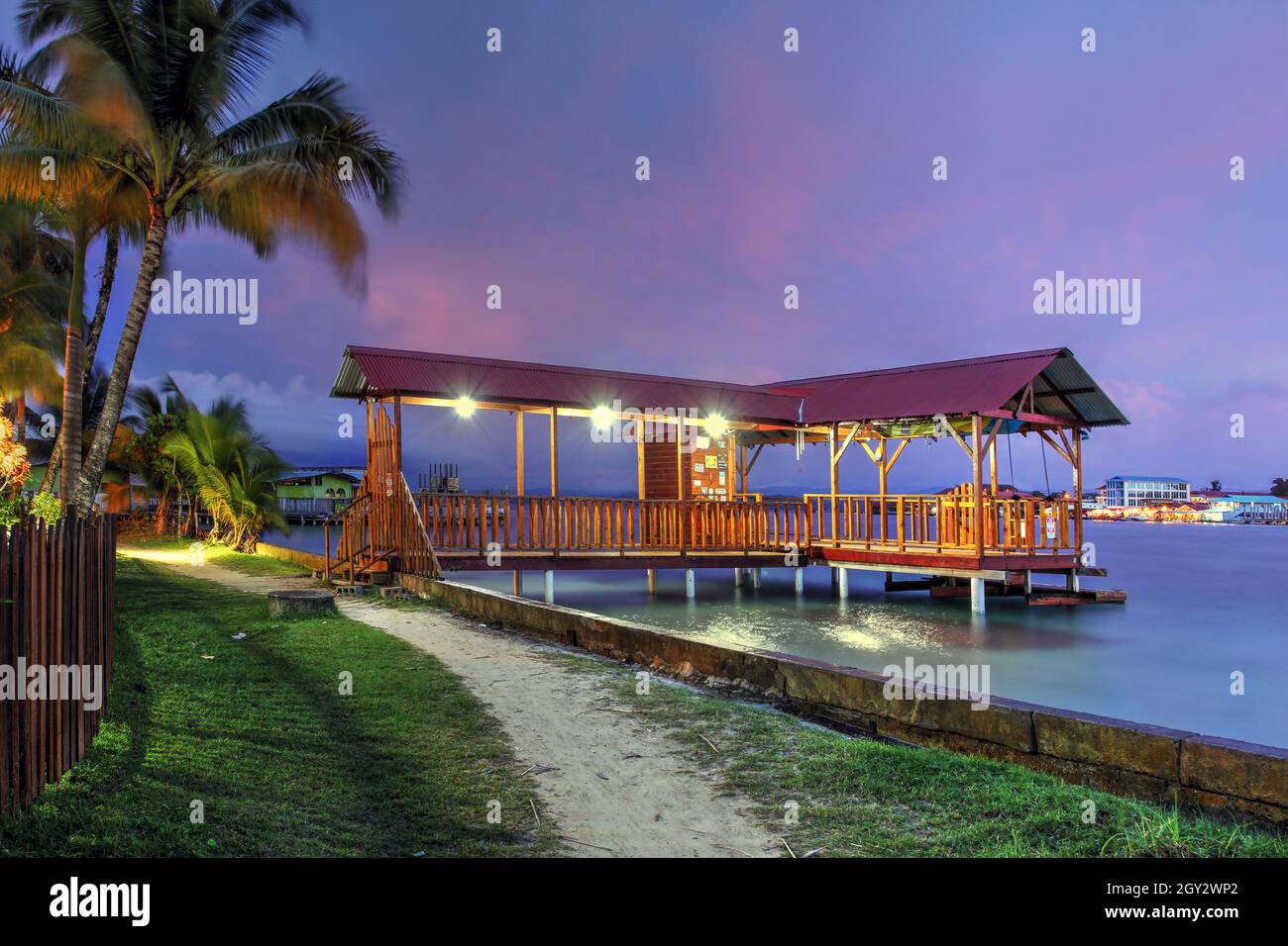 Passagierpier auf Carenero Island, direkt gegenüber der Stadt Bocas in der Provinz Bocas del Toro in Panama, unter einem wunderschönen violetten Abendlicht. Stockfoto