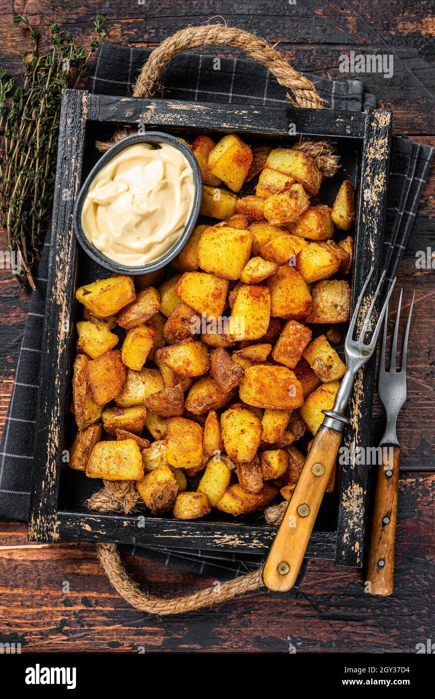 Patatas Bravas traditionelle spanische Kartoffeln Snack Tapas. Dunkler Holzhintergrund. Draufsicht Stockfoto