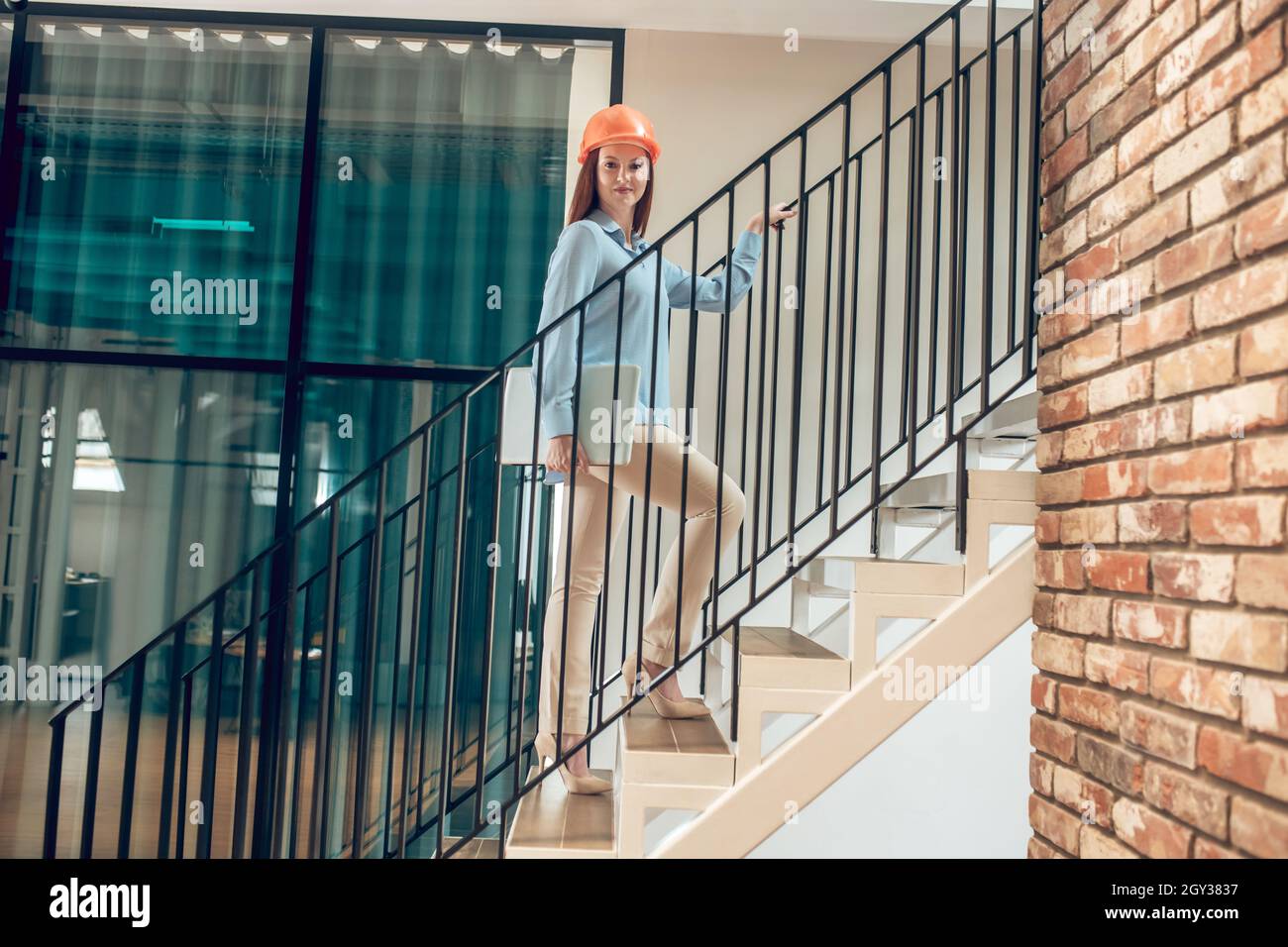 Glückliche Frau mit Laptop auf der Treppe Stockfoto