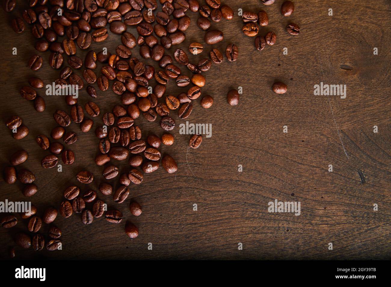 Holzstruktur Board mit verstreuten Kaffeebohnen roh Stockfoto