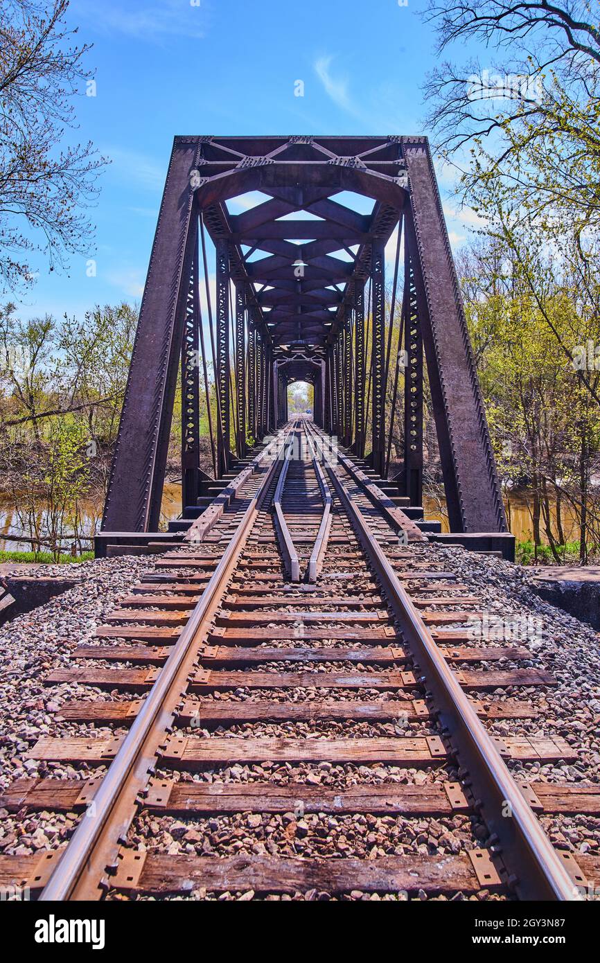 Vertikal der Bahngleise mit Stahlbrücke über den Fluss Stockfoto