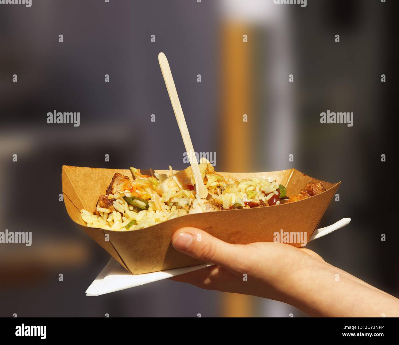 Der Kunde hält Papaer Bowld mit leckeren Speisen auf dem Prager Latino-Bauernmarkt in der Hand. Stockfoto