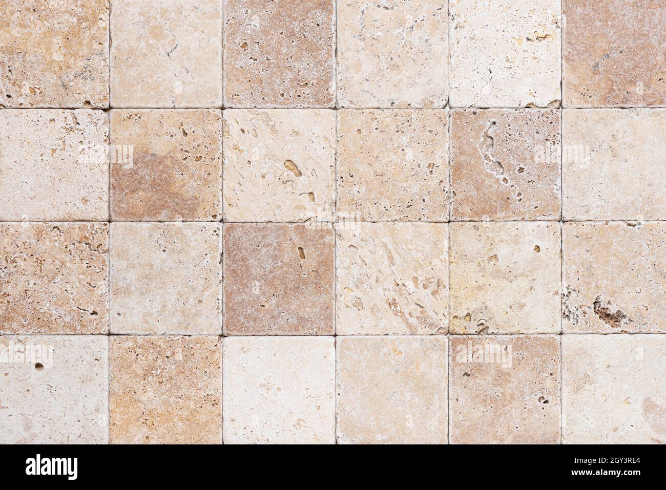 Natursteinmauer aus kleinen quadratischen Teilen. Hintergrund oder Textur für den Innenraum. Stockfoto